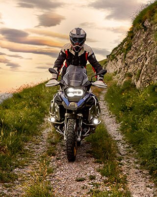 Scène de conduite avec la BMW R 1250 GS Adventure en montagne sur un chemin de terre