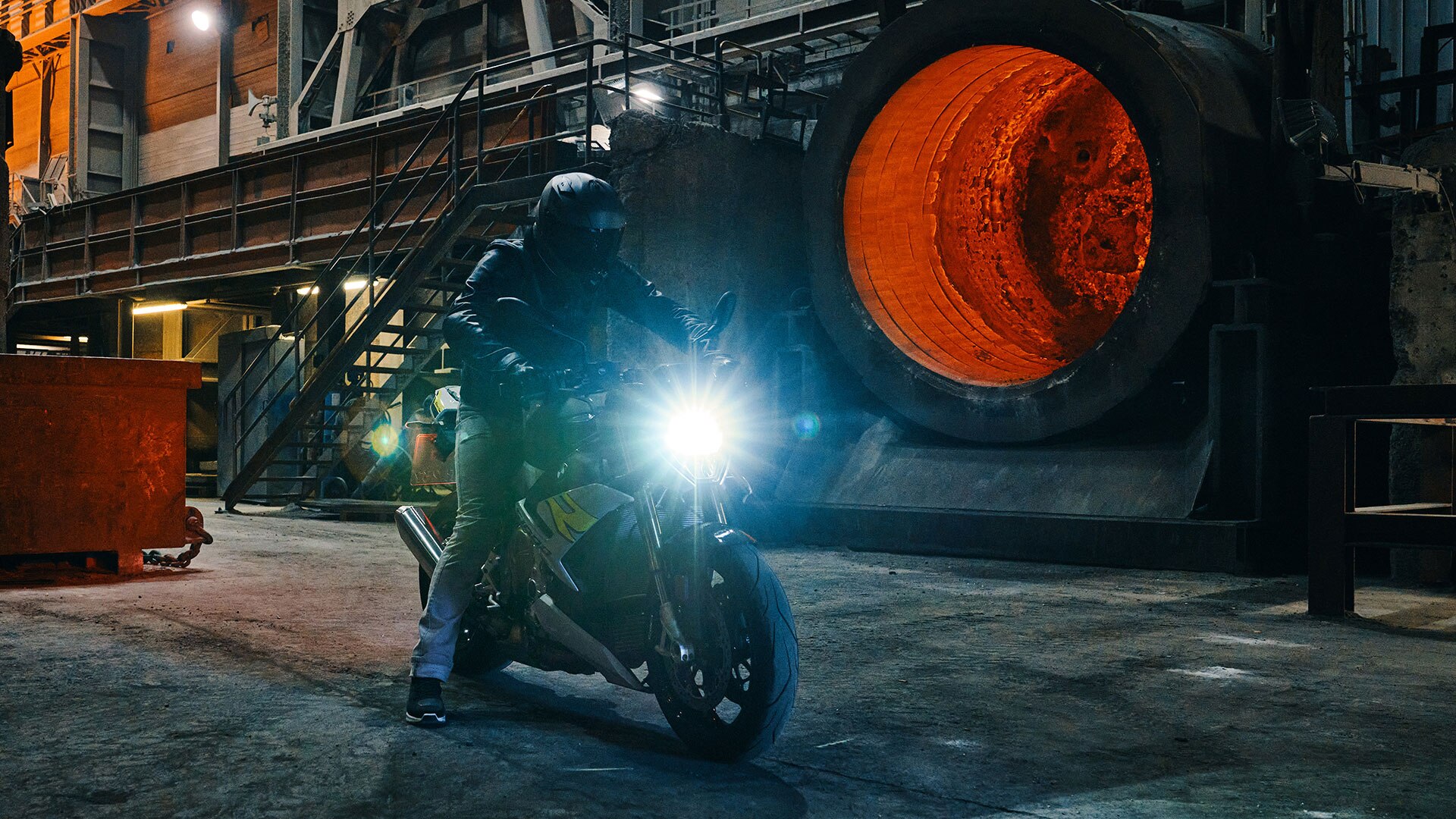 Wir sehen die S 1000 R in den legendären M Farben vor einer Betonwand fahrend.