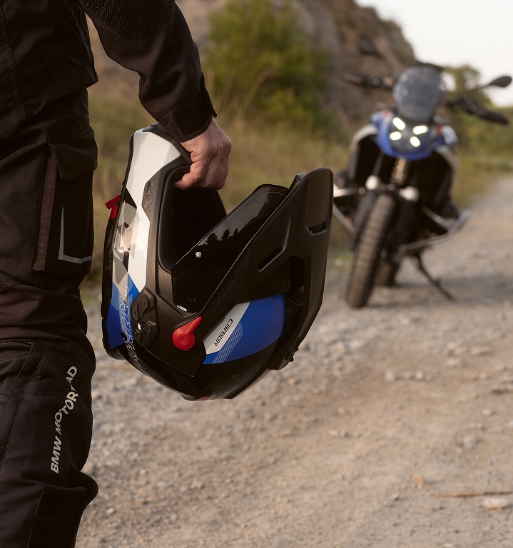 Une personne tient un casque de moto dans sa main.